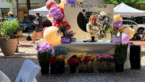 Narcisa demonstrating Ikebana at Soirée on the Lane at Bethesda Row with balloons and fresh flowers